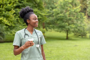 Kahve molası. Afro-Amerikan kahvesini parkta içerken gülümsüyor.