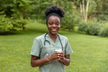 Kahve molası. Afro-Amerikan kahvesini parkta içerken gülümsüyor.