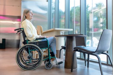 Rehabilitasyon merkezi. Kafkasyalı orta yaşlı kadın rehabilitasyon merkezinde tekerlekli sandalyede.