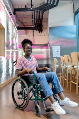 İyileşme. Rehabilitasyon merkezinde tekerlekli sandalyedeki Afrikalı Amerikalı genç kadın.
