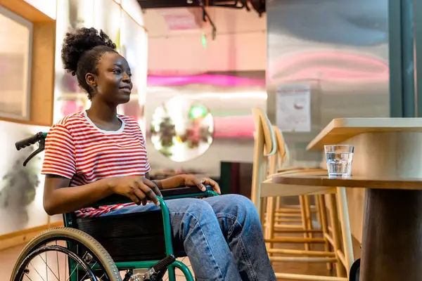 İyileşme. Rehabilitasyon merkezinde tekerlekli sandalyedeki Afrikalı Amerikalı genç kadın.