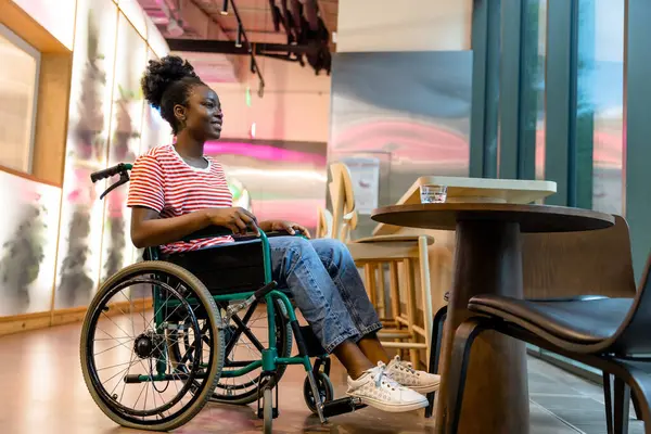 İyileşme. Rehabilitasyon merkezinde tekerlekli sandalyedeki Afrikalı Amerikalı genç kadın.