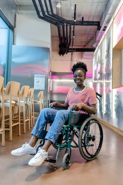 İyileşme. Rehabilitasyon merkezinde tekerlekli sandalyedeki Afrikalı Amerikalı genç kadın.