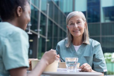 Birlikte öğle yemeği. İş arkadaşları birlikte yemek yiyor, mutlu ve mutlu görünüyorlar.