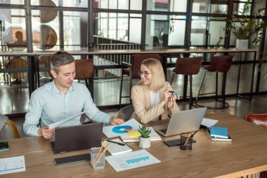 Meslektaşlar. İş arkadaşları ofiste masada oturup proje detaylarını tartışıyor.