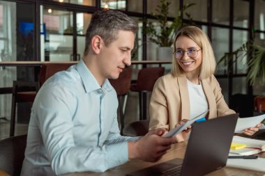Meslektaşlar. İş arkadaşları ofiste masada oturup proje detaylarını tartışıyor.