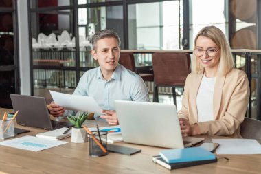 Meslektaşlar. İş arkadaşları ofiste masada oturup proje detaylarını tartışıyor.