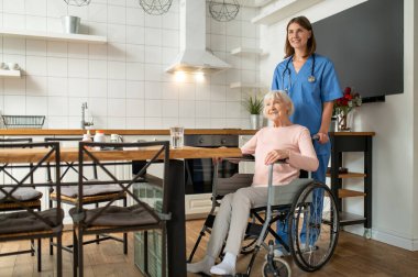 Bakım evi. Bakım asistanı ve hastası mutlu ve gülümsüyor.