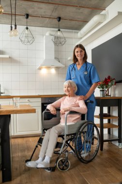 Bakım evi. Bakım asistanı ve hastası mutlu ve gülümsüyor.