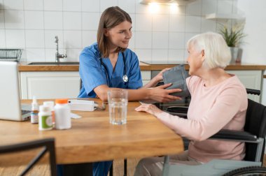 Blood pressure check. Nurse checking the blood pressure of an elderly lady