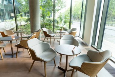 Kahve. Rahat sandalyeleri ve yuvarlak masaları olan modern bir kafe.