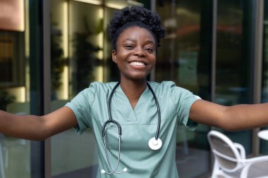 Olumlu duygular. Güzel Afro-Amerikan kadın laboratuvar önlüğü içinde mutlu ve gülümsüyor.