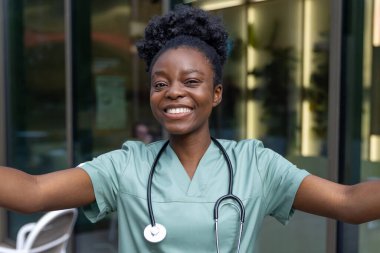 Olumlu duygular. Güzel Afro-Amerikan kadın laboratuvar önlüğü içinde mutlu ve gülümsüyor.