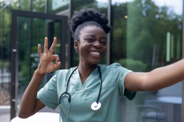 Olumlu duygular. Güzel Afro-Amerikan kadın laboratuvar önlüğü içinde mutlu ve gülümsüyor.