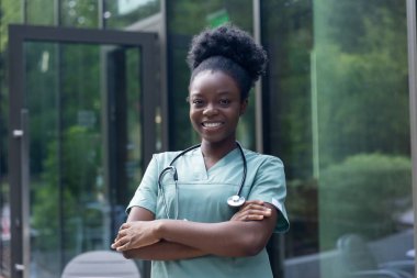 Olumlu duygular. Güzel Afro-Amerikan kadın laboratuvar önlüğü içinde mutlu ve gülümsüyor.