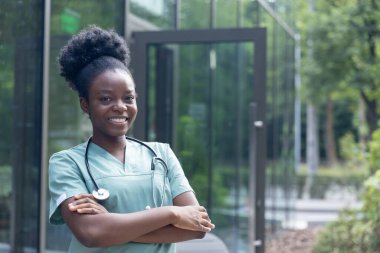 Olumlu duygular. Güzel Afro-Amerikan kadın laboratuvar önlüğü içinde mutlu ve gülümsüyor.