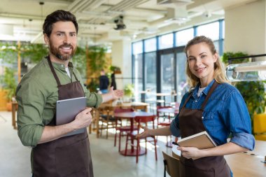 Pizzacı. Pizzacıda mutlu ve kendinden emin iki garson müşterileri bekliyor.