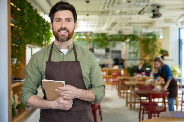 Müşterileri bekliyorum. Önlüklü genç sakallı adam pizzacıda müşterisini beklerken kendinden emin görünüyor.