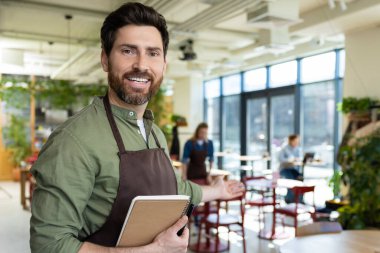 Müşterileri bekliyorum. Önlüklü genç sakallı adam pizzacıda müşterisini beklerken kendinden emin görünüyor.