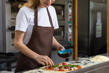 Mutfakta pizza hazırlayan kadın evde yemek yapıyor.