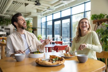 Restoranda salata ve pizza yiyen insanlar yemeklerini evde yemekten zevk alıyorlar.