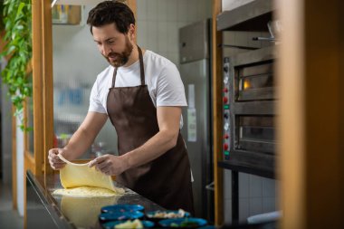 Yemek pişirmek. Pizzacıda çalışan ve pizza için hamur hazırlayan bir adam.