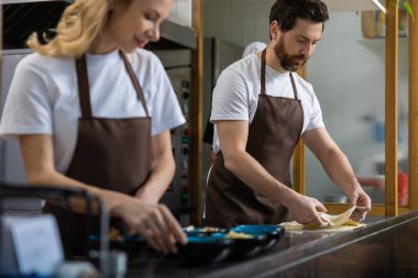 Pizzacı. Pizzacıda çalışan ve pizza için hamur hazırlayan iki kişi.