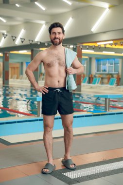 Havuzdaki adam. Genç adam havuzda mayo giyiyor.