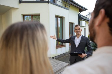 Emlakçı evin önünde çift ev gezdiriyor.