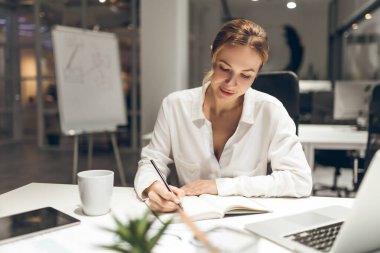 Günümüz ofis ortamında iş işleri için dizüstü bilgisayar kullanan kadın