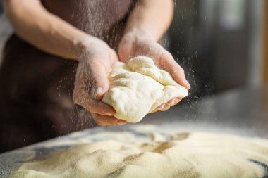 İnsan hamur mutfağını yoğurur, pizzayı içeride sıkıca hazırlar.