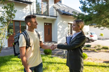 El sıkışalım. Emlakçı yeni bir müşteriyle el sıkışıyor ve ikisi de memnun görünüyor.