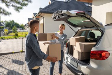 Hareket ediyor. Genç çift kıyafetlerini kutulara koyup taşınmaya hazırlanıyorlar.