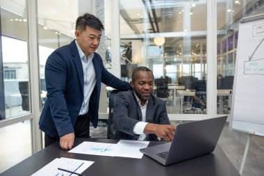 Takım çalışması. İş arkadaşları ofiste yeni bir proje üzerinde çalışıyor ve fikirleri tartışıyorlar.