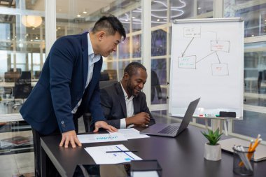 Takım çalışması. İş arkadaşları ofiste yeni bir proje üzerinde çalışıyor ve fikirleri tartışıyorlar.