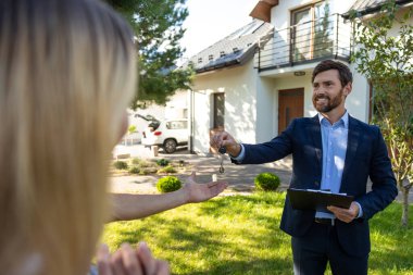 Yeni evim. Emlakçı anahtarı yeni bir evden müşterilere veriyor.