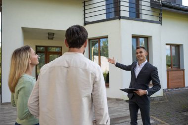 Emlakçı evin önünde çift ev gezdiriyor.