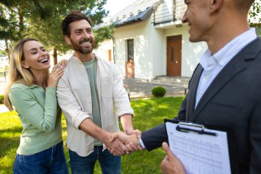 Mutlu çift, temiz gökyüzü ile banliyödeki yeni evde temsilciyi selamlıyor.