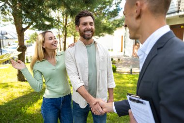 Mutlu çift, temiz gökyüzü ile banliyödeki yeni evde temsilciyi selamlıyor.