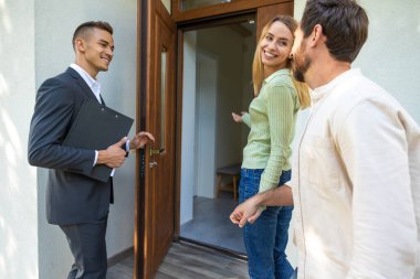 Menajer müşterilerini temiz gökyüzü ile banliyö ortamında yeni bir eve davet ediyor.