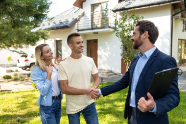 - Anlaştık. Emlakçı başarılı bir anlaşmadan sonra müşterilerle konuşuyor.