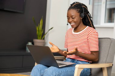 Evden çalışıyorum. Bilgisayarlı, gülümseyen güzel bir kadın. Mutlu görünüyor.