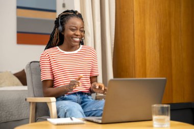 İnternetten konuşuyorum. Memnun genç kadın internette konuşuyor ve mutlu ve heyecanlı görünüyor.