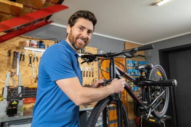 Garajda bisikletli tamirci bisiklet tamiri için çalışıyor.