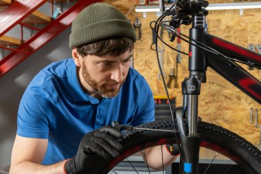 Modern profesyonel atölyede bisiklet tamir eden yetenekli bir adam.