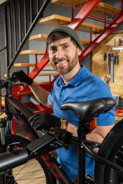 Modern profesyonel atölyede bisiklet tamir eden yetenekli bir adam.