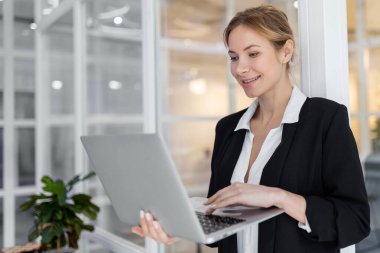 Ofiste. Beyaz, güzel görünümlü, dizüstü bilgisayarı olan bir kadın.