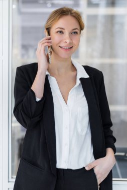 Telefon var. Kendine güvenen genç bir iş kadını arıyor ve ilgili ve memnun görünüyor.