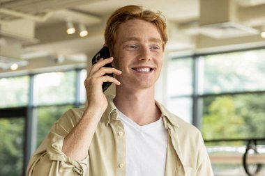 Telefon var. Gülümseyen genç adam telefonda konuşurken heyecanlı görünüyor.