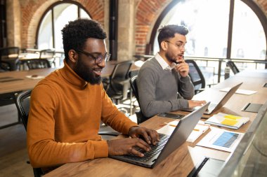 Birlikte çalışmak. Ofiste birlikte çalışan iki genç adam.